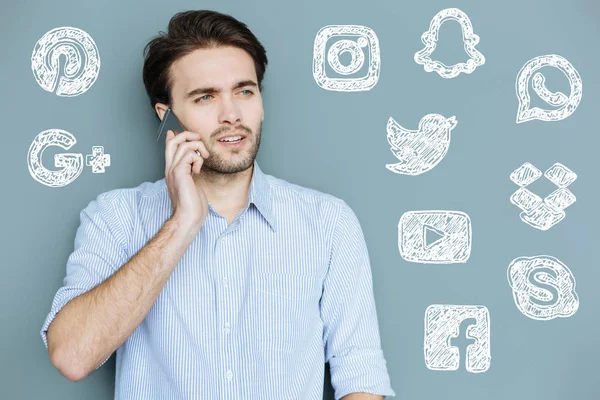 Ocupado blogger hablando por teléfono y luciendo reflexivo — Foto de Stock