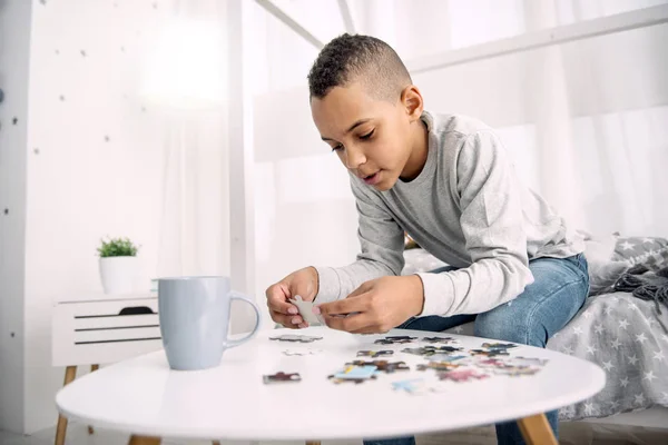 Erfreut positive Junge sammelt Puzzle — Stockfoto