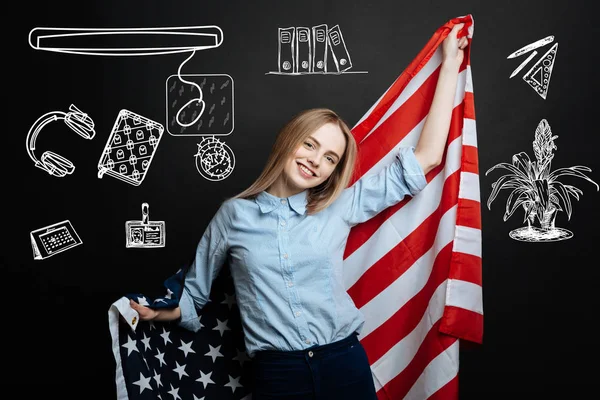 Positive student holding a flag of the USA after entering American university