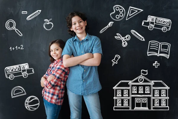 Des enfants heureux debout les bras croisés et attendant l'école — Photo