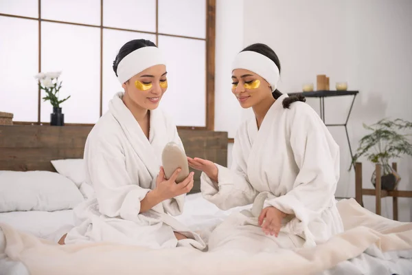 Mujeres hermosas mirando la loción corporal — Foto de Stock