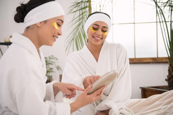 Mujeres jóvenes alegres discutiendo cosméticos de la piel — Foto de Stock