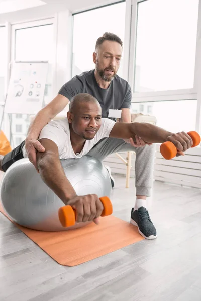 Joven positivo levantando pesas — Foto de Stock