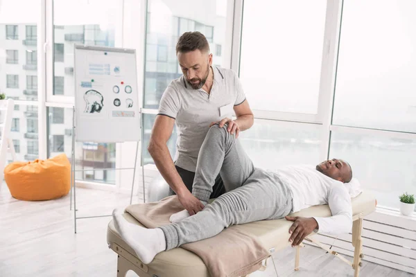 Mooie professionele therapeut permanent in de buurt van zijn patiënt — Stockfoto
