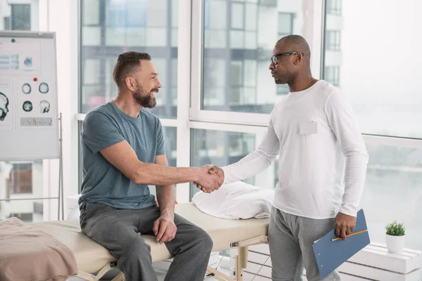 Joyful patient och läkare skakar hand — Stockfoto