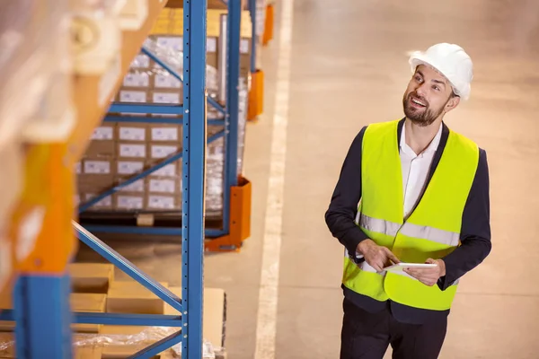 Alegre hombre inteligente mirando las cajas — Foto de Stock