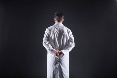 Akıllı kendine güvenen adam ellerini arkasından tutarak