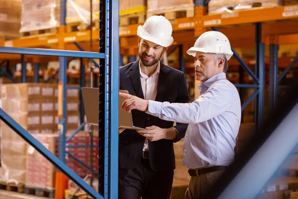 Un buen hombre serio apuntando a la estantería — Foto de Stock