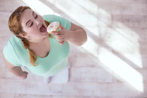 Plump young woman seduced by sweets — Stock Photo, Image