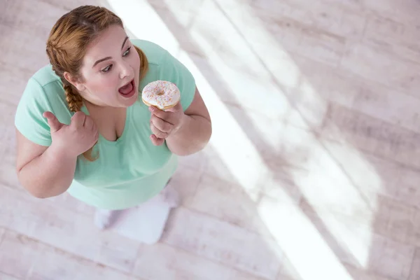 Zwaarlijvige jonge vrouw die het eten van snoep — Stockfoto