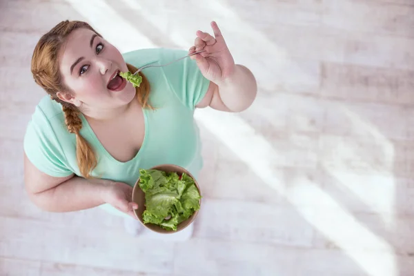 Mollige junge Frau isst Salat — Stockfoto