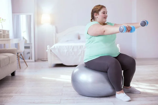 Sorrindo jovem mulher fazendo novo tipo de exercícios — Fotografia de Stock