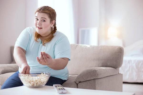 Pleasant young woman offering you some popcorn — Stock Photo, Image