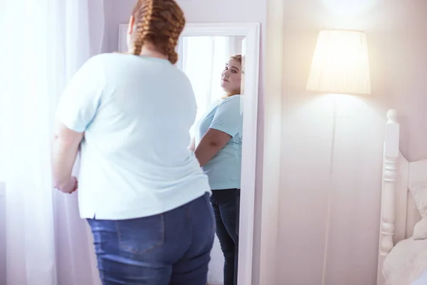 Obese woman looking at herself in the mirror — Stock Photo, Image