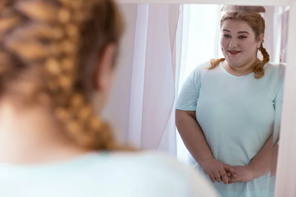 Agradable mujer guapa mirando en el espejo — Foto de Stock