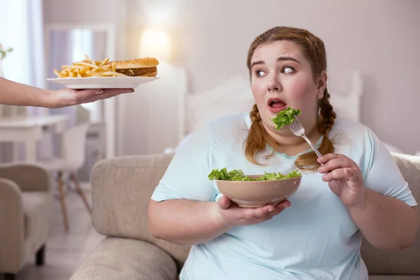 Stout red-head woman deciding which type of food to choose — Stock Photo, Image