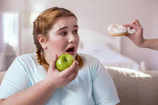 Knubbig ung kvinna som innehar grönt äpple — Stockfoto