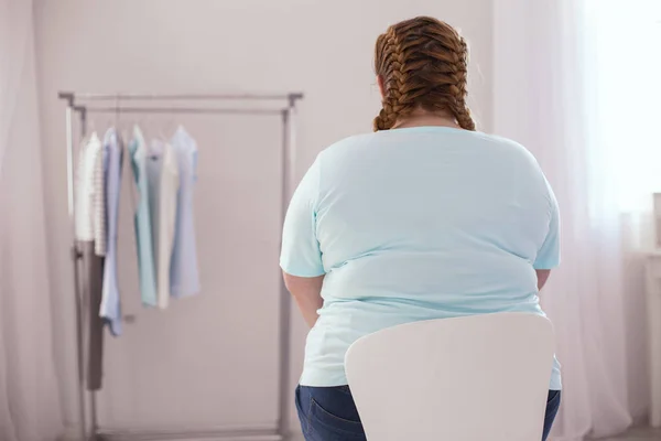 Mujer joven y robusta sentada en la silla — Foto de Stock