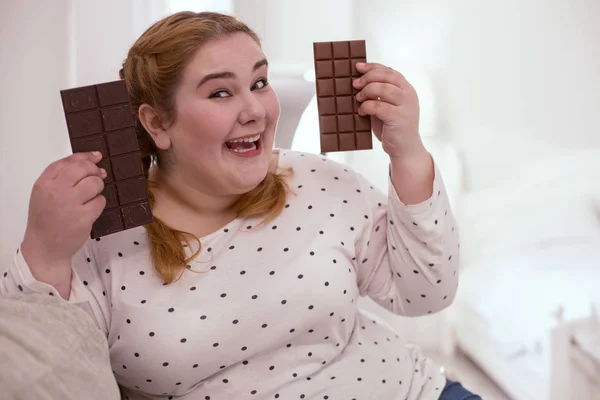 Lächelnde junge Frau genießt Schokolade — Stockfoto