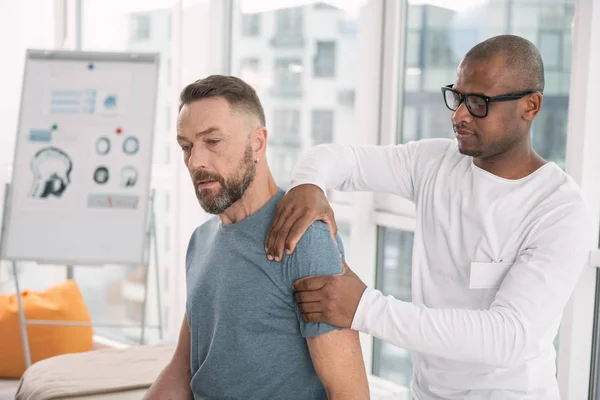 Kluger netter Mann, der seine Patienten an der Schulter berührt — Stockfoto