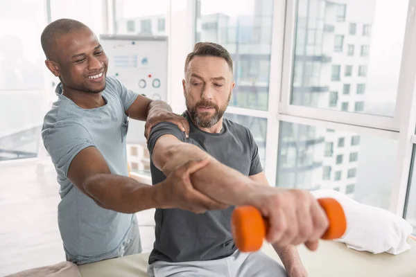 Glad trevlig terapeut leende att hans patient — Stockfoto