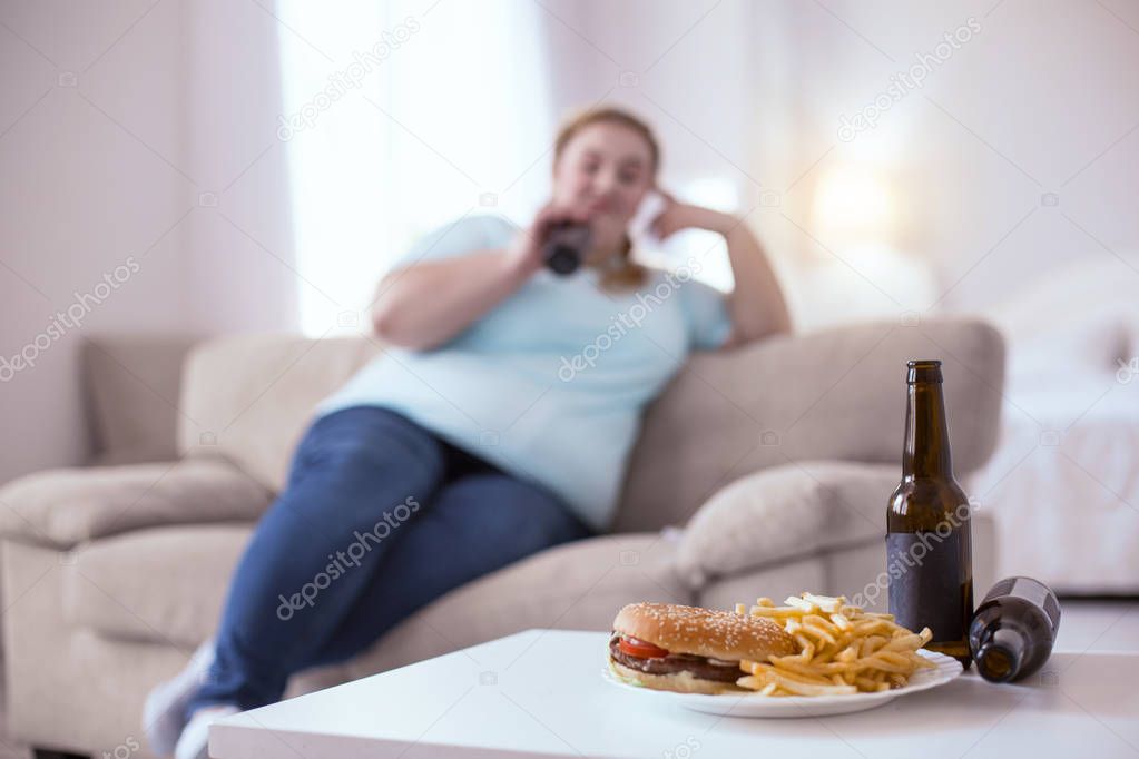Obese woman maintaining unhealthy lifestyle