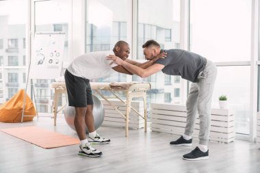 Bükme egzersiz yaparak güzel neşeli adam