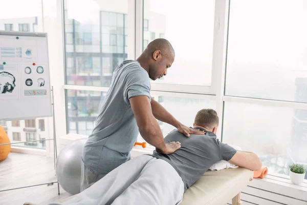 Kundige leuk orthopedist werken met zijn patiënt — Stockfoto