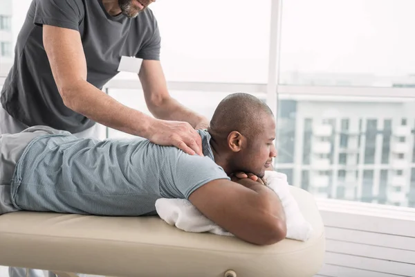 Agradável homem bonito apreciando a massagem — Fotografia de Stock