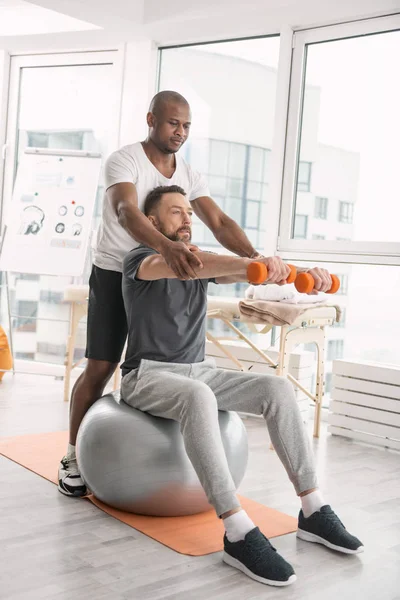 Allvarlig fina tränare fastställande patienter händer — Stockfoto