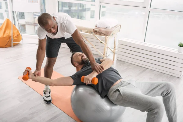 Entrenador cualificado serio que trabaja con un paciente — Foto de Stock