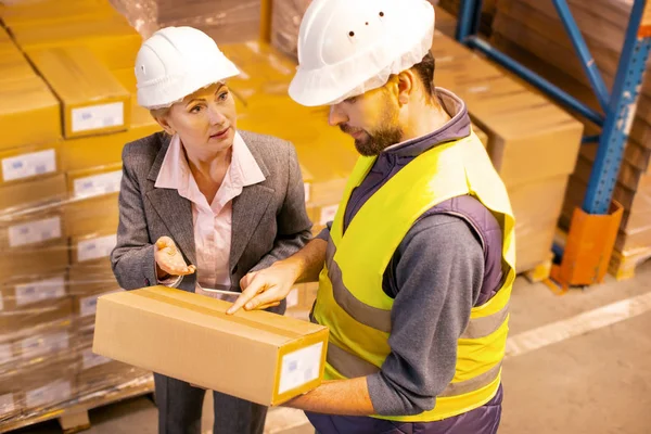 Un repartidor serio señalando la caja — Foto de Stock