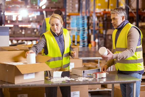 Nette ernsthafte Leute beim Kistenpacken — Stockfoto