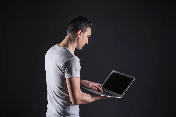 Zachwycony przystojny mężczyzna patrząc na ekran laptopa — Zdjęcie stockowe