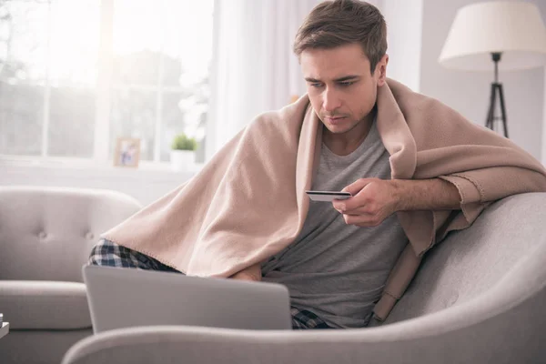 Agradable hombre guapo sosteniendo su tarjeta de crédito — Foto de Stock