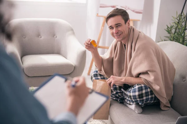 Hombre positivo alegre sosteniendo su medicina — Foto de Stock