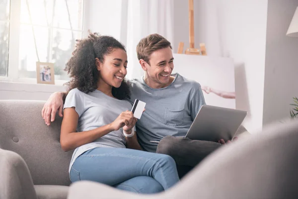 Jovem positiva segurando um cartão de crédito — Fotografia de Stock