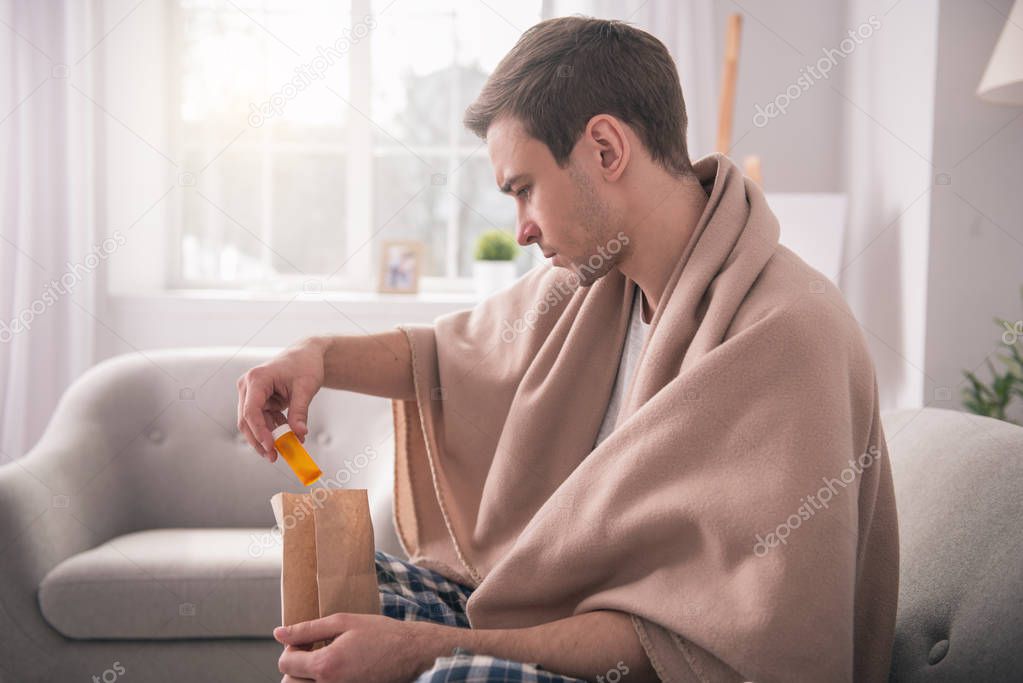 Serious young man taking out the medicine