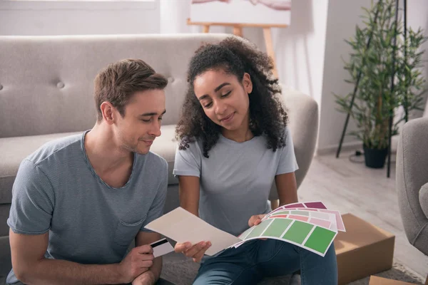 Joven pareja alegre mirando los colores — Foto de Stock