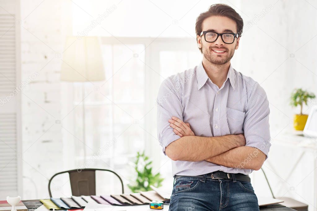 Happy businessman standing near the table