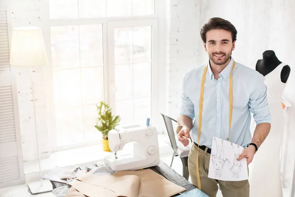 Smiling dressmaker profesional sosteniendo sus bocetos — Foto de Stock