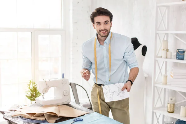 Feliz modista profesional sosteniendo sus bocetos — Foto de Stock