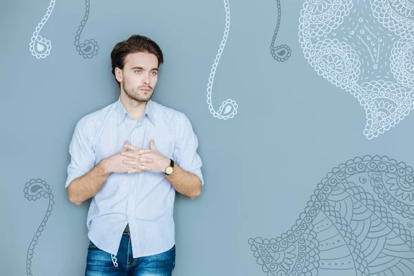 Waist up of serious puzzled man keeping fingers crossed — Stock Photo, Image