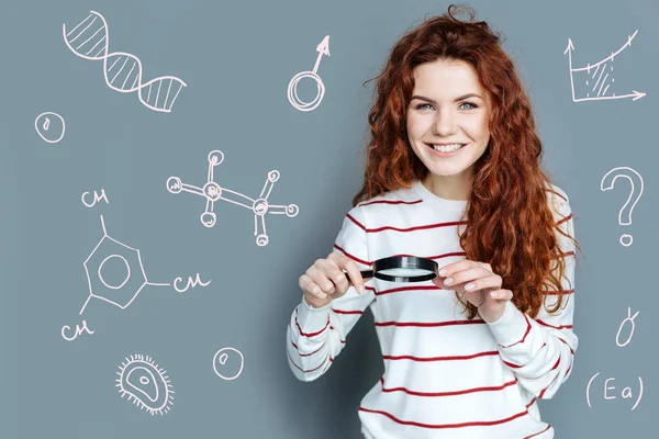 Científico emocional sosteniendo una lupa y sonriendo — Foto de Stock