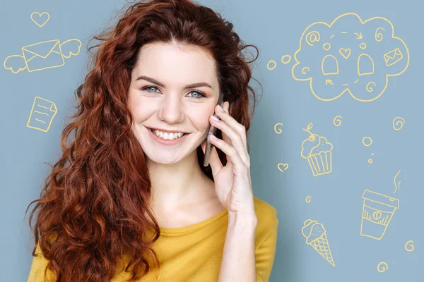 Emotional blogger smiling while talking on the phone — Stock Photo, Image