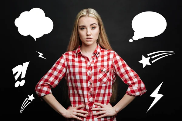 Jonge blonde vrouw met haar handen op de heupen en kijken geïnteresseerd — Stockfoto