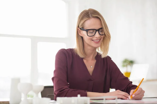 Pensive reflective businesswoman writing down agenda — Stock Photo, Image