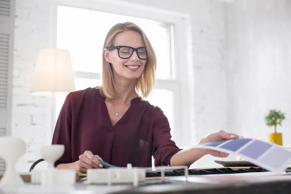 Diseñadora femenina positiva trabajando en interiores — Foto de Stock