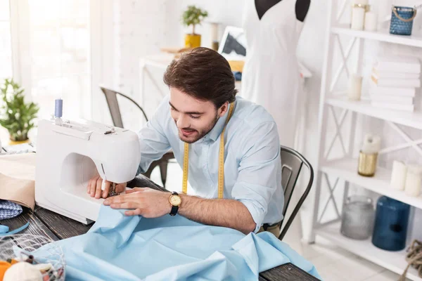 Sastre sonriente trabajando en una máquina de coser — Foto de Stock