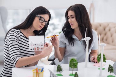 Yenilikçi planlama. Dalgın özürlü kadın ve masada poz ve alternatif enerji modelleri ile çalışma meslektaşım